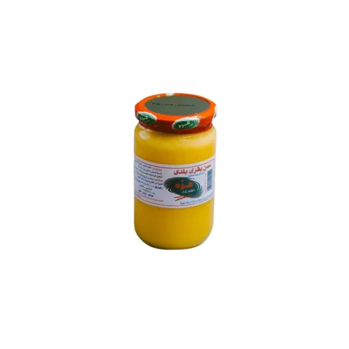 A jar of Azza Cow Ghee 900g placed on a rustic kitchen surface under warm lighting.
